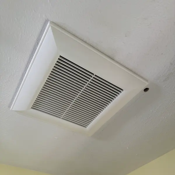 New bathroom exhaust fan grille in a textured ceiling