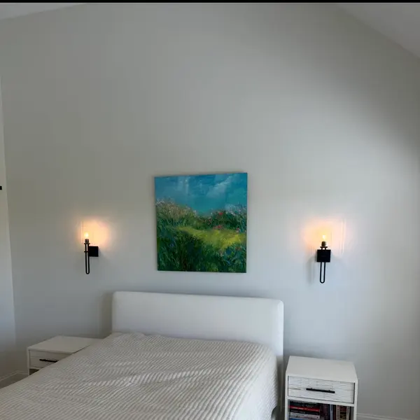 Bedroom with a wall sconce mounted either side of the bed