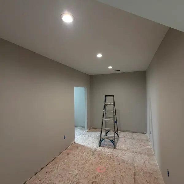 Finished basement room with fresh drywall and new recessed lights