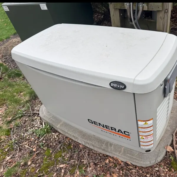 22 kW standby generator installed on a concrete pad beside the gas meter at the side of a house