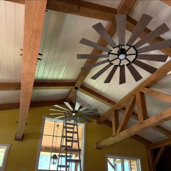 Two large windmill-style ceiling fans hung from a vaulted timber-frame ceiling